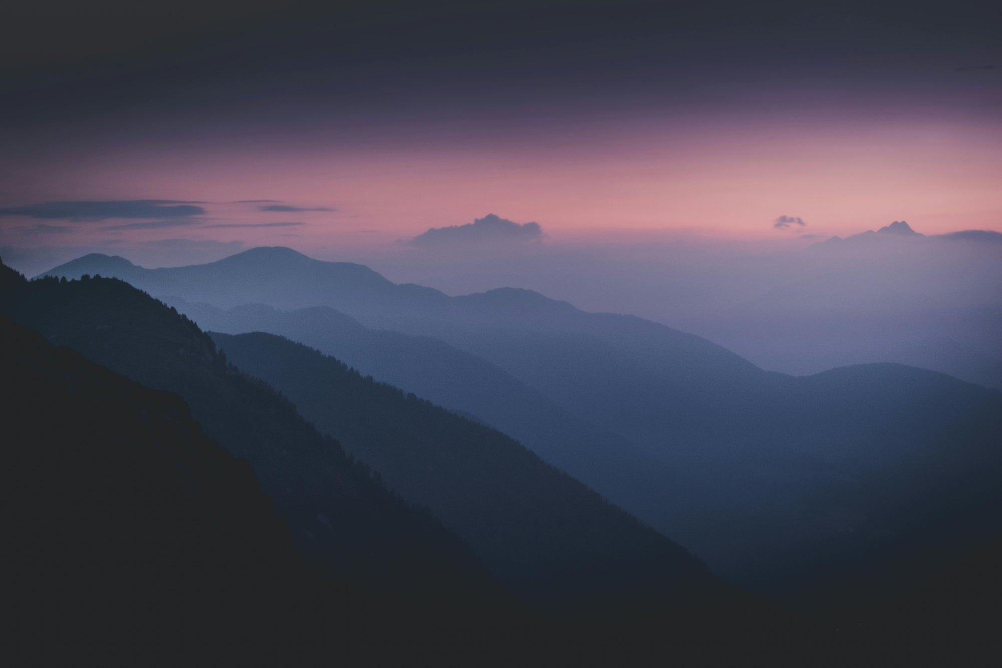 Hazy mountain landscape with a purple and pink sky