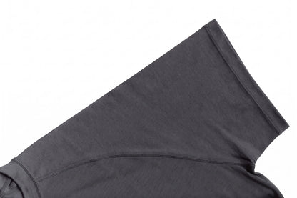 Close-up of a dark gray athletic merino t-shirt showing the shoulder seam and ribbed collar on a white background.
