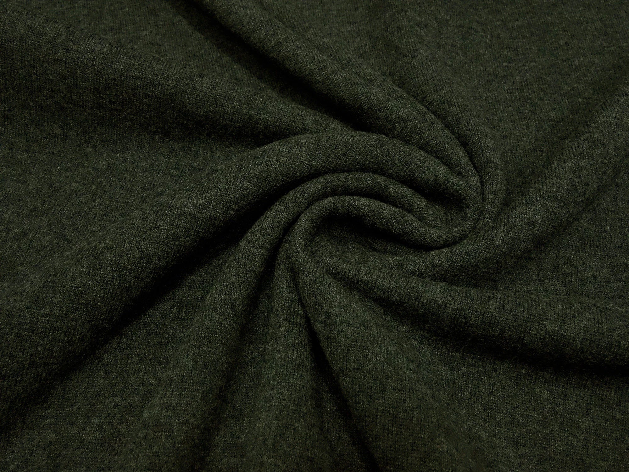 Close-up of dark green fabric with folds

